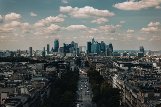Captivating aerial view of Paris showcasing the impressive skyline of La Défense under a dramatic sky.