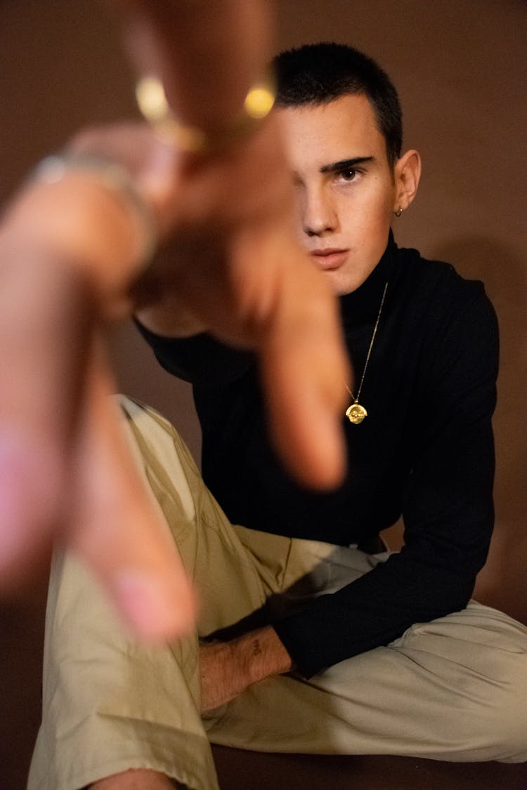 Man In Black Long Sleeves And Khaki Pants Sitting On A Floor