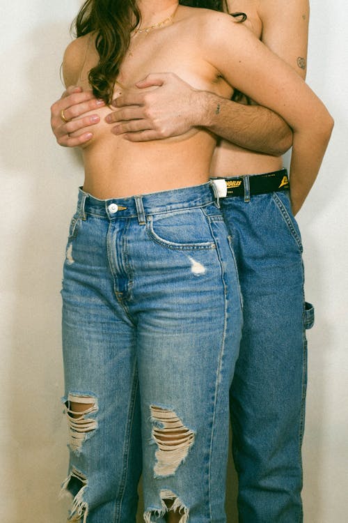 A Man and Woman in Denim Pants Standing Together