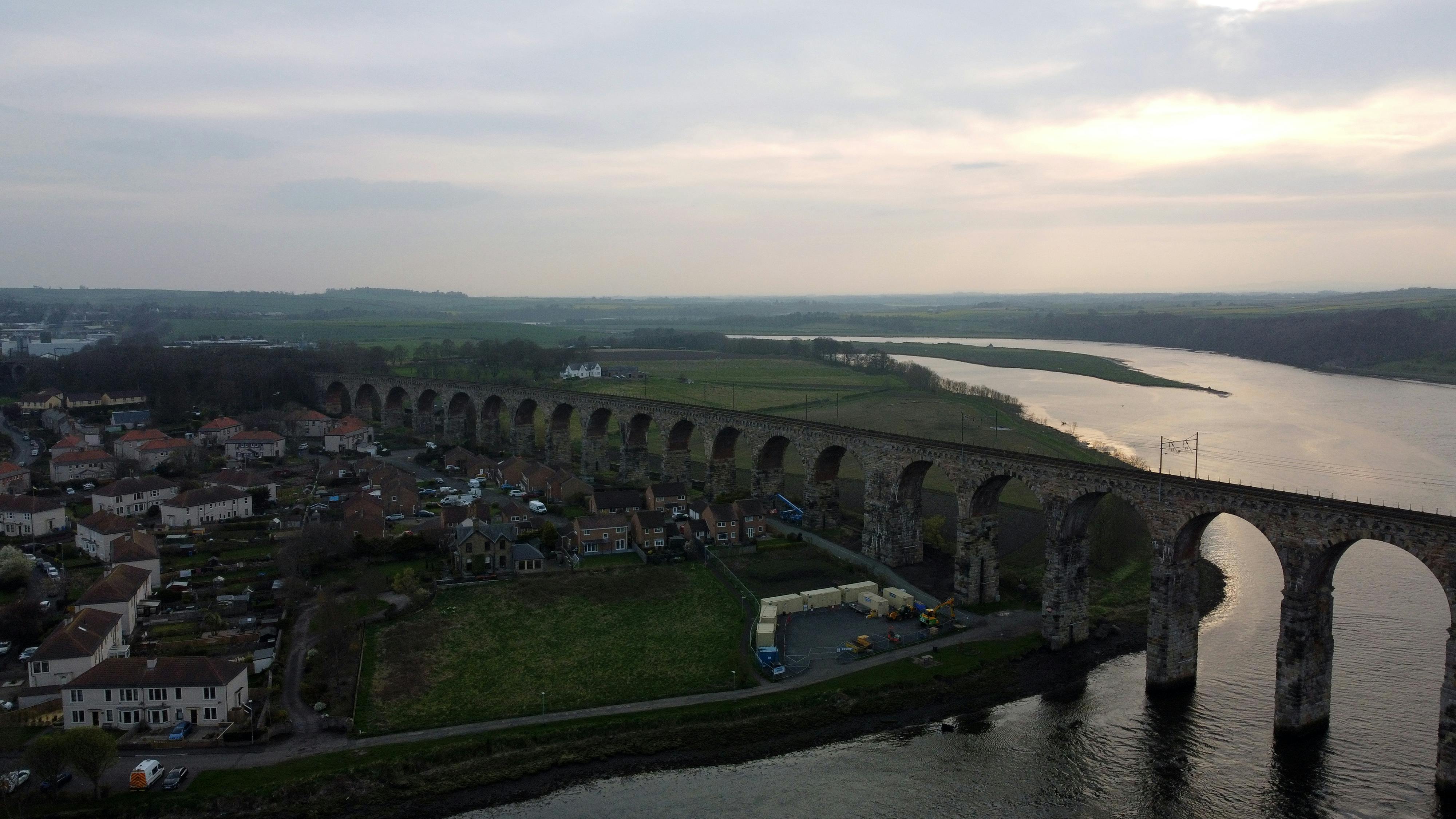 A stunning aerial view of the Royal Border Bridge in England stretching over a serene river.