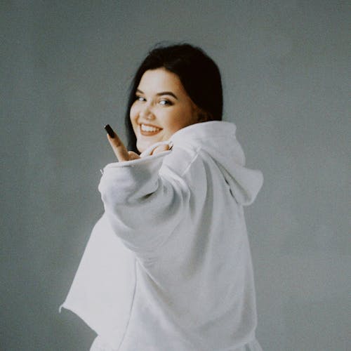 Woman in White Hoodie doing a Hand Gesture 