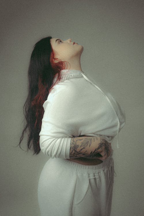 A Side View of a Woman in White Long Sleeves Looking Up