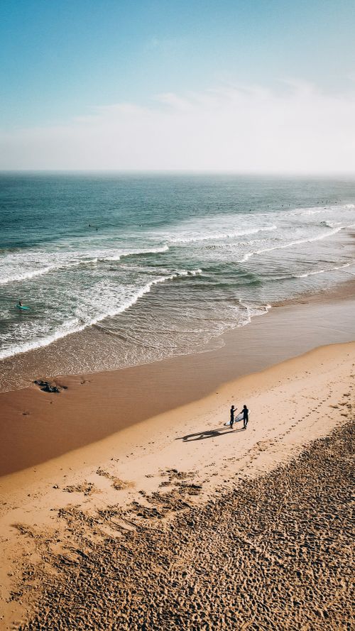 Free Explore the serene beauty of Cascais beach with its golden sands and turquoise waves from an aerial perspective. Stock Photo
