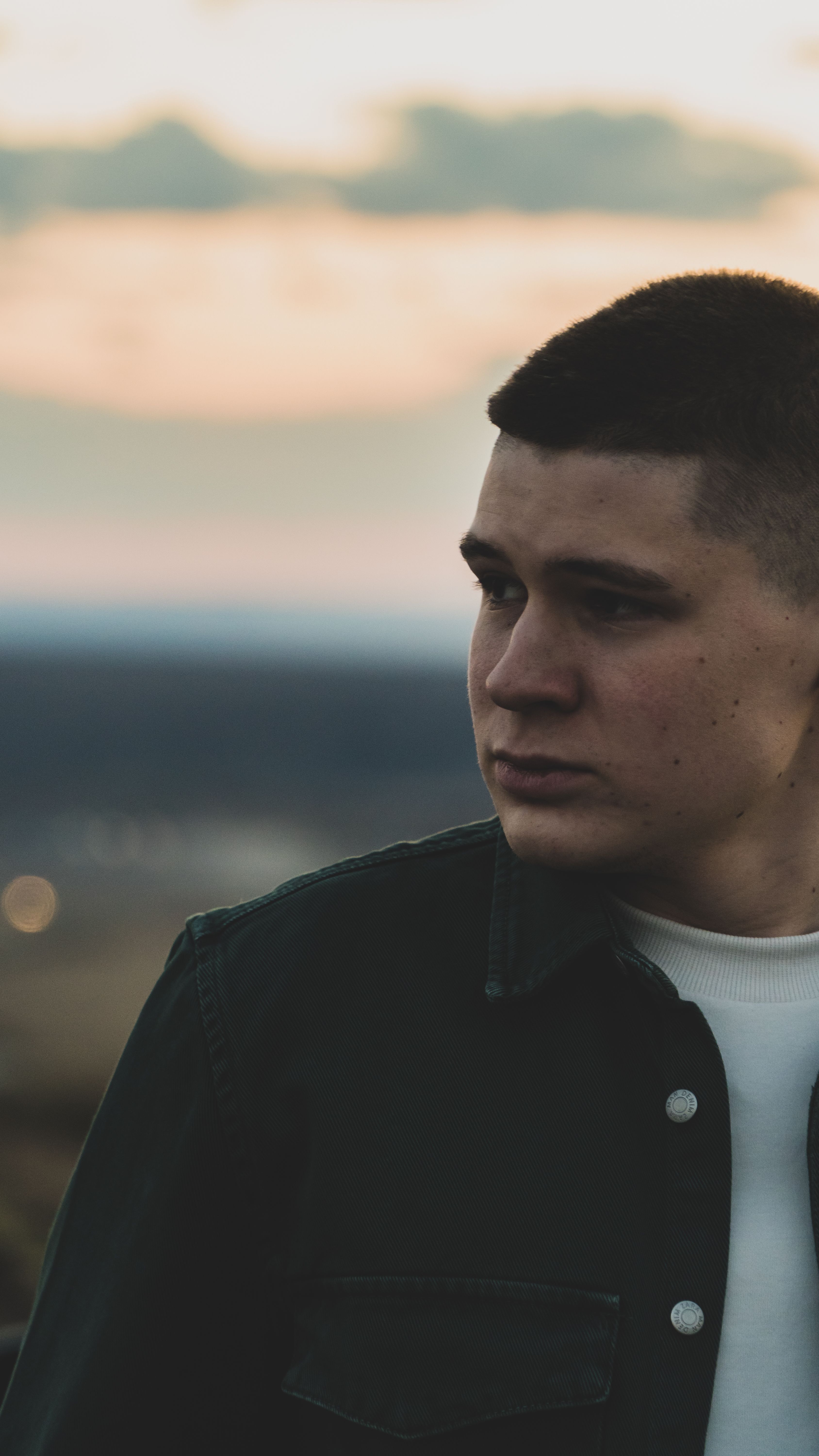 A close-up portrait of a fashionable young man with a stylish haircut during sunset in Saint Petersburg, Russia.