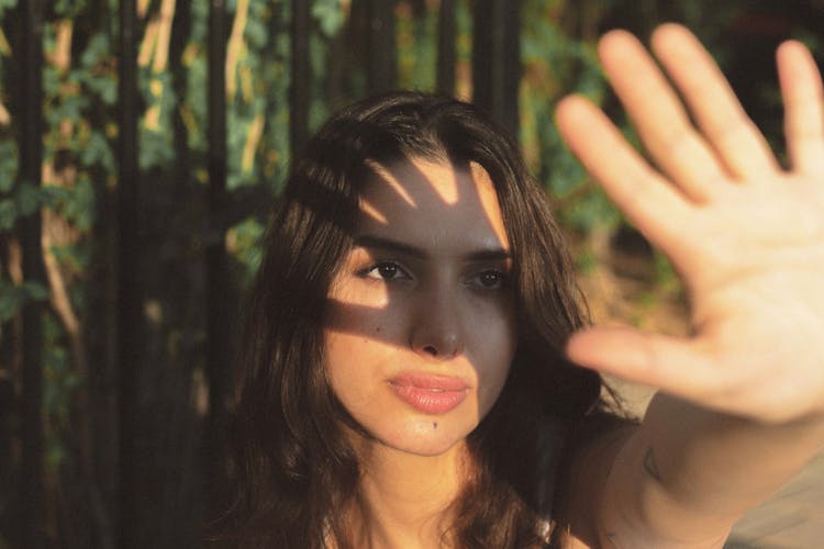 Shadow Of A Woman's Hand On Her Face