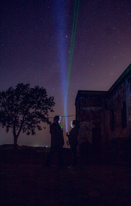 People with Flashlights under Clear Sky at Night