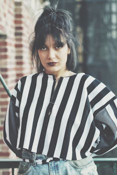 Stylish woman in a bold striped shirt posing outdoors, showcasing urban fashion in Los Angeles.