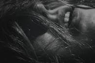 一张黑白特写照片，展现了一个人的嘴巴和头发，传递出亲密感