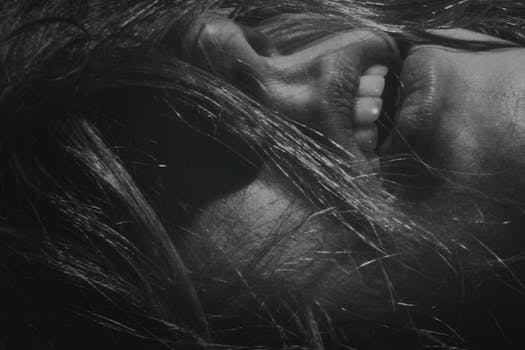 一张黑白特写照片，展现了一个人的嘴巴和头发，传递出亲密感