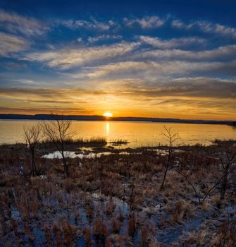 A tranquil sunset over Weaver Lake in Minnesota with a dramatic sky reflecting on the water.