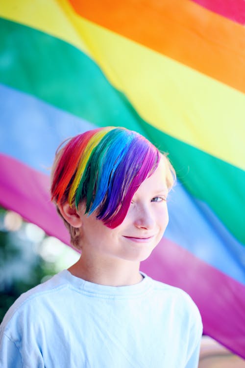 Free Boy Wearing White Shirt With Iridescent Hair Color Infront of Flag Stock Photo