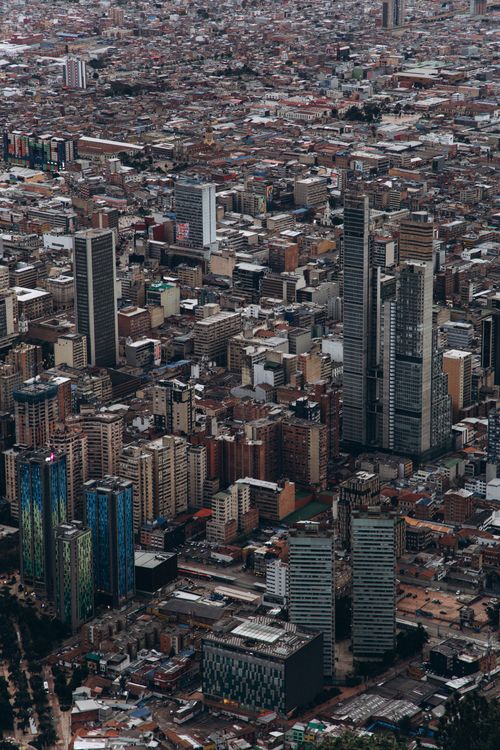 Free Drone shot capturing the dense cityscape and towering skyscrapers of a bustling urban area. Stock Photo