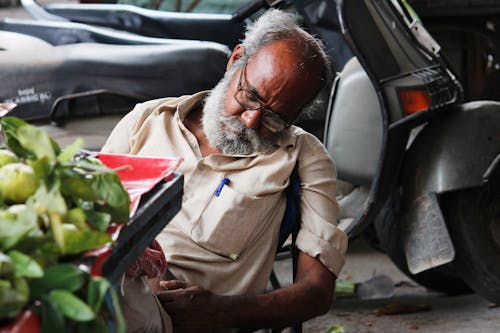 Old Man Sleeping near Street Stall