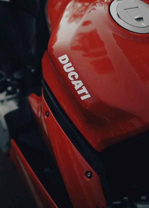 Free Detailed close-up of a red sports motorcycle showcasing sleek design and brand logo. Stock Photo