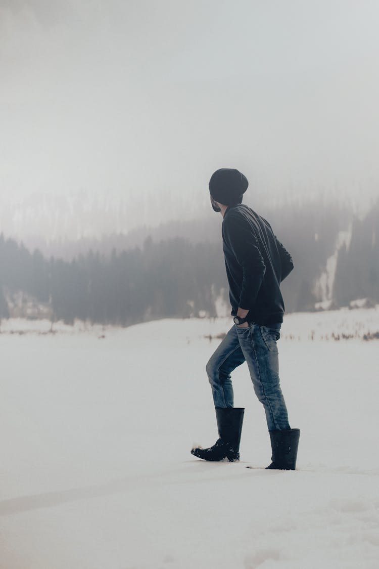 A Man Wearing Boots While Walking On The Snow