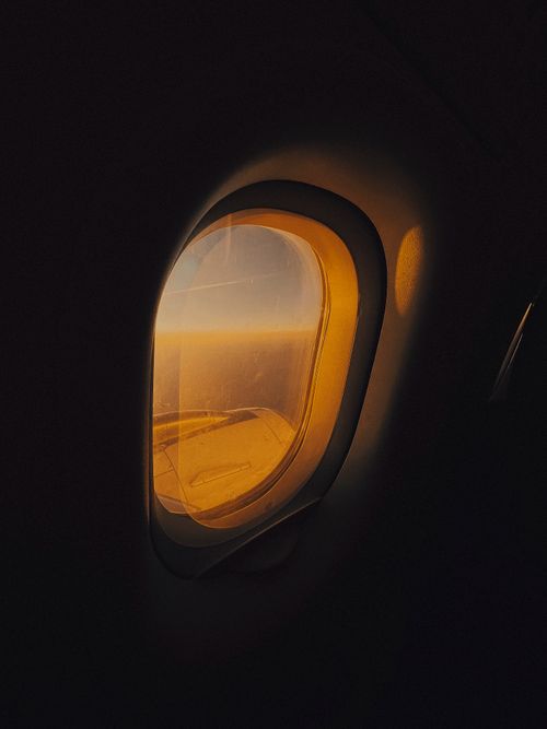 Free Golden hues of sunset as seen through an airplane window during flight. Stock Photo