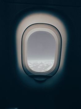 Serene view of clouds through an airplane window, capturing a minimalistic style at high altitude.