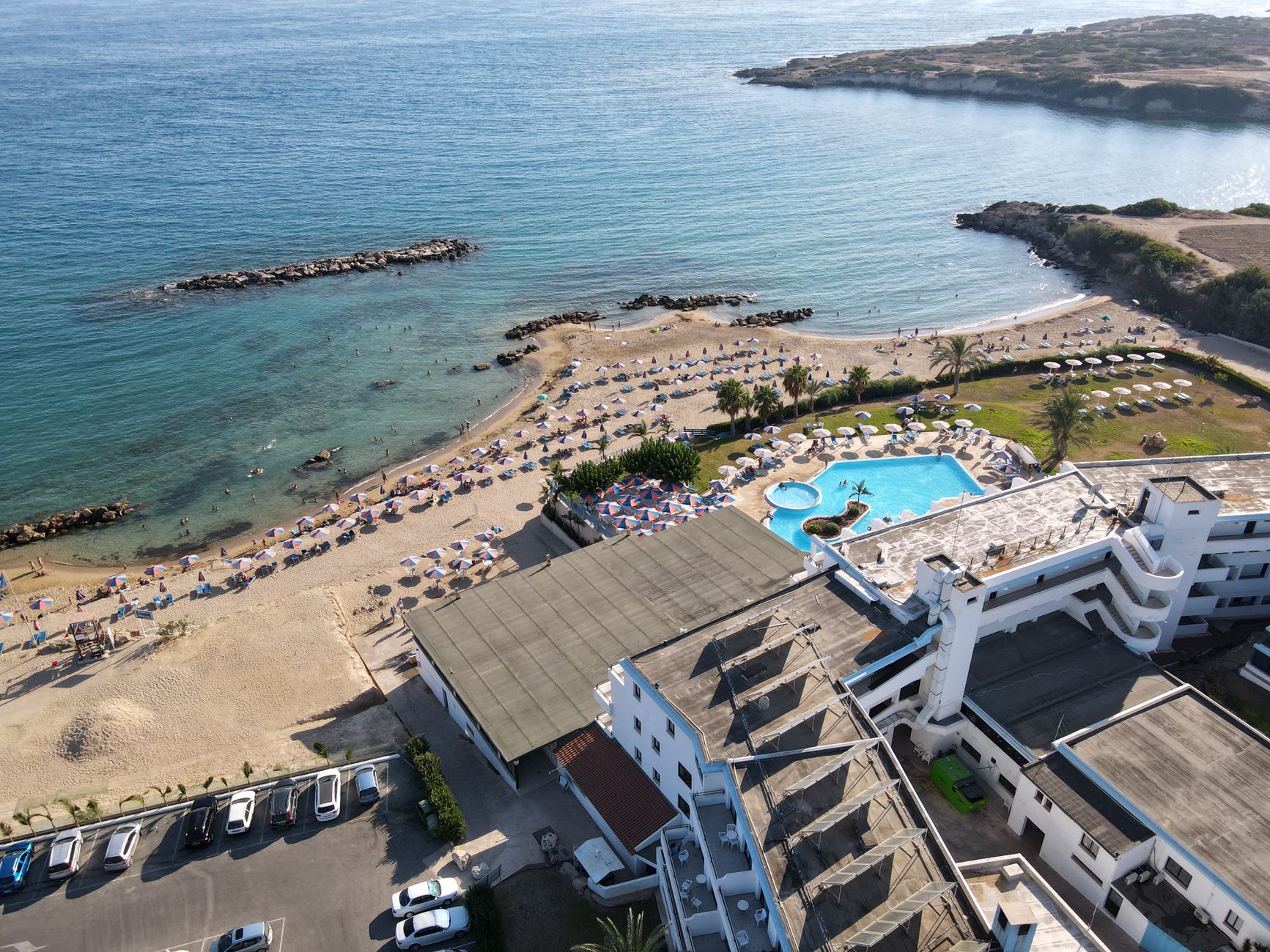 Aerial view of a beachfront resort in Paphos with pools and the Mediterranean Sea