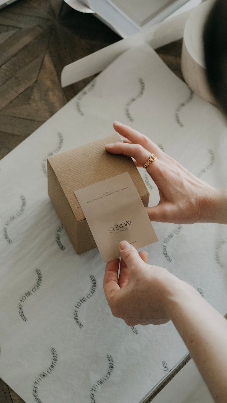 Woman Putting Label On Cardboard Box