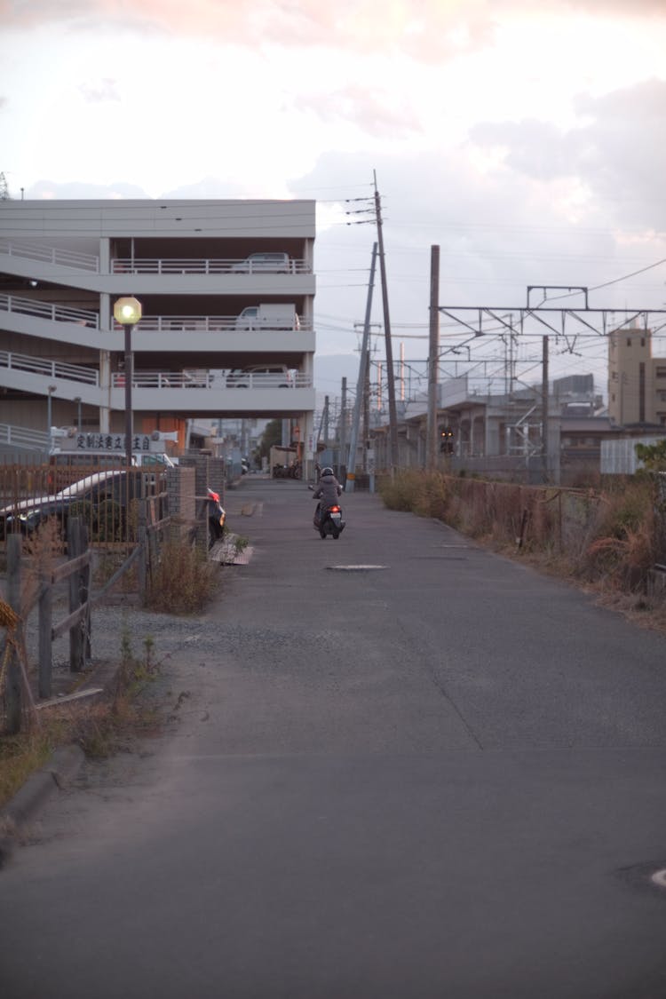 Someone Riding A Scooter Between Blocks Of Flats