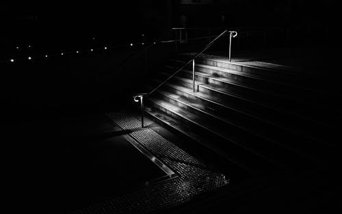 A Grayscale Photo of a Stairs with Handrail