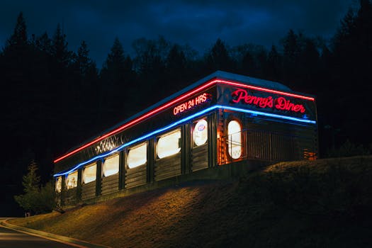 Diner exterior with vibrant neon lights at night, offering a retro ambiance.