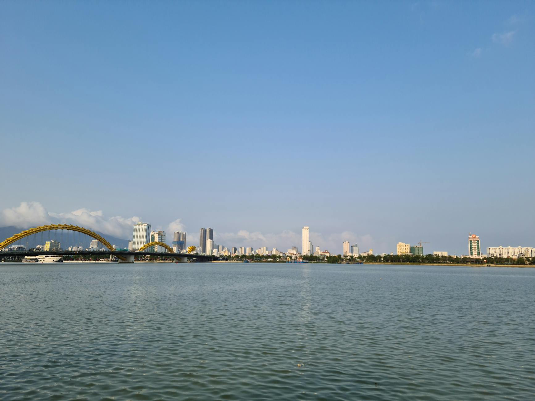 在蔚蓝天空下,Da Nang 天际线与横跨 Han River 的龙桥交相辉映的美丽景色。