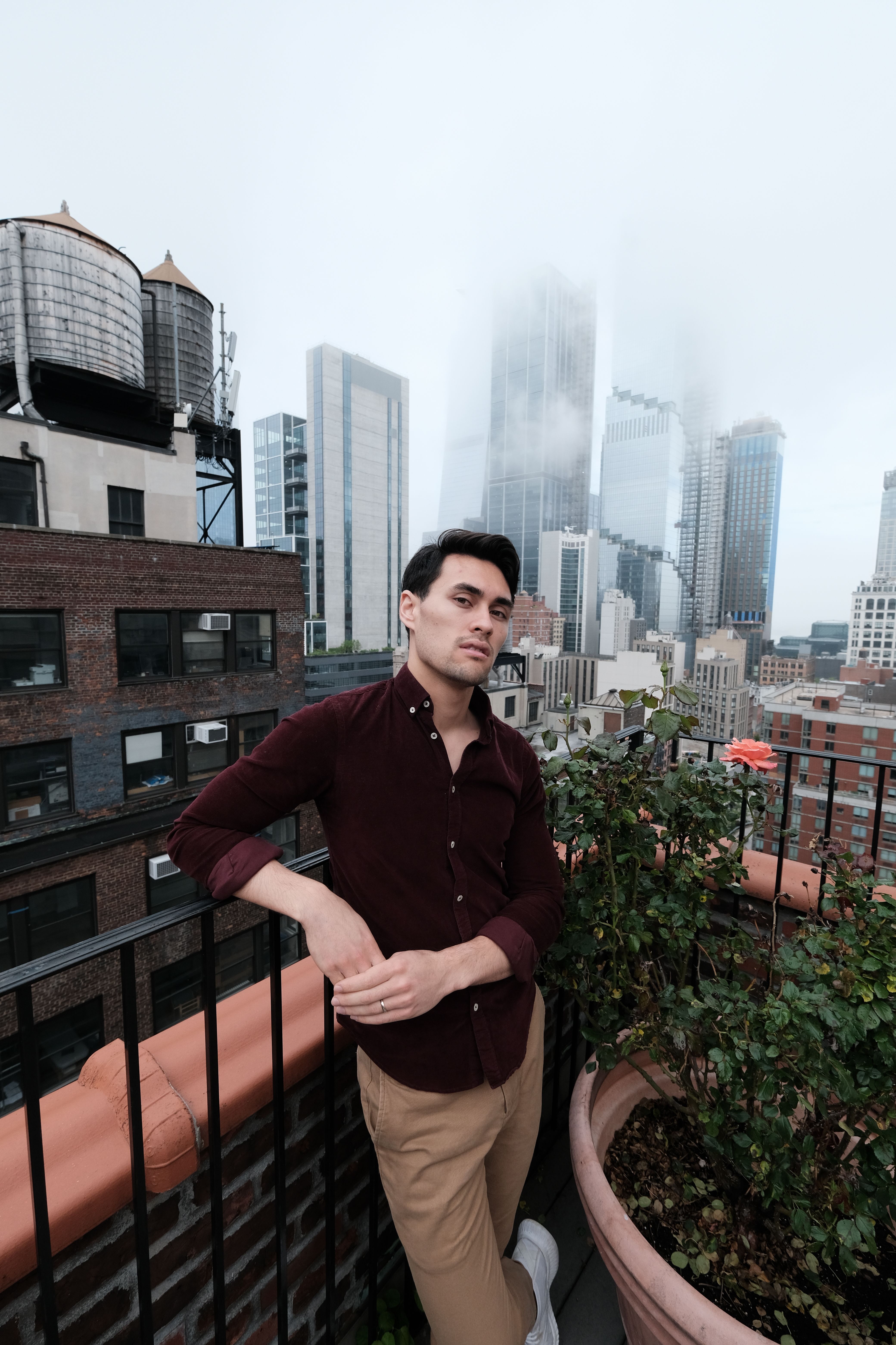 A Man in Maroon Shirt Posing on the Rooftop · Free Stock Photo