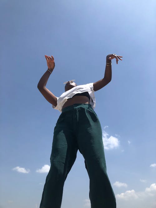 Person in White T-Shirt Against Blue Sky