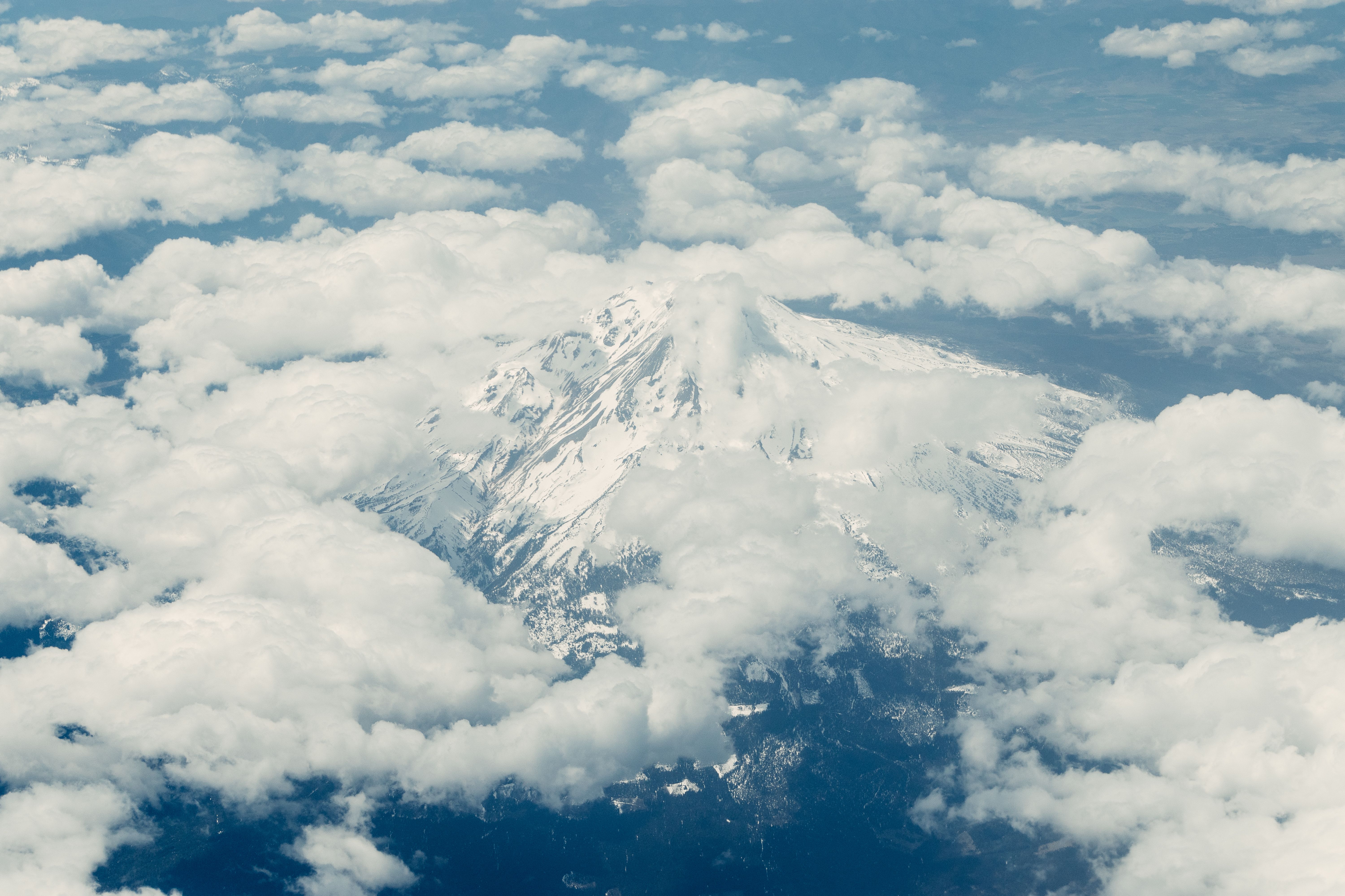 An Aerial Photography of a Snow Covered Mountain Under the Blue Sky and ...