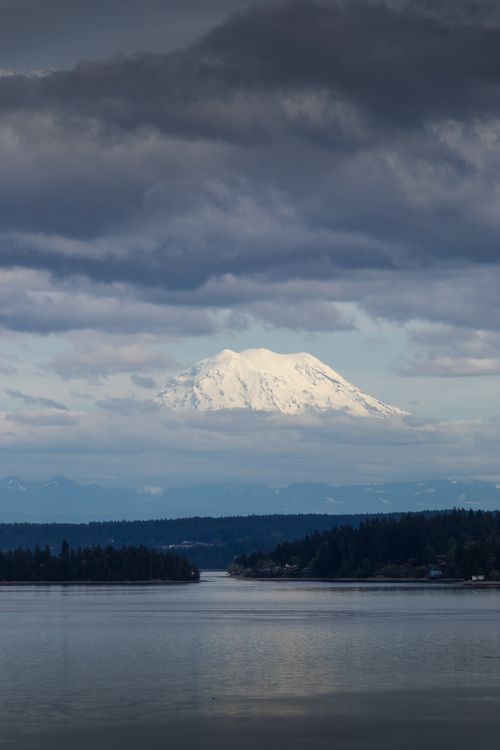 Free A stunning view of a snow-capped mountain reflecting over a tranquil lake. Stock Photo