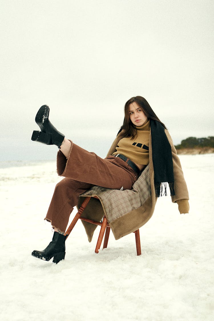 Beautiful Woman Sitting On Chair On Winter Day With Raised Leg