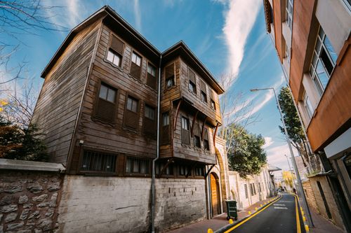Free A captivating wooden building stands on a narrow city street, evoking a sense of urban charm. Stock Photo