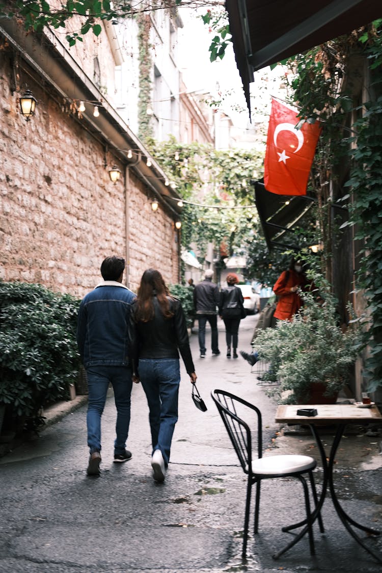 A Back View Of Couples Walking On The Street