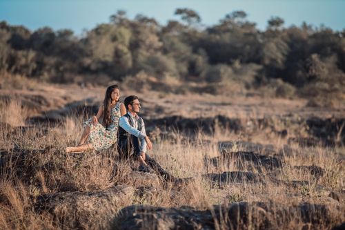 Free A couple sitting in a serene grassfield, enjoying a peaceful moment outdoors. Stock Photo