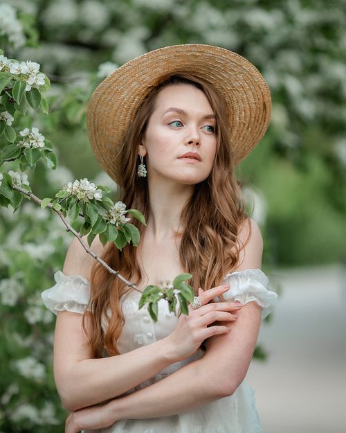 Free A serene portrait of a woman in a straw hat embracing nature's beauty. Stock Photo