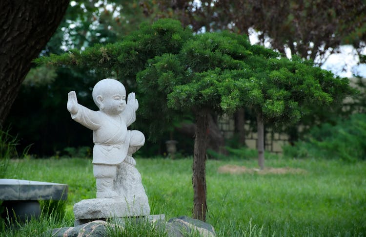 White Statue On A Garden