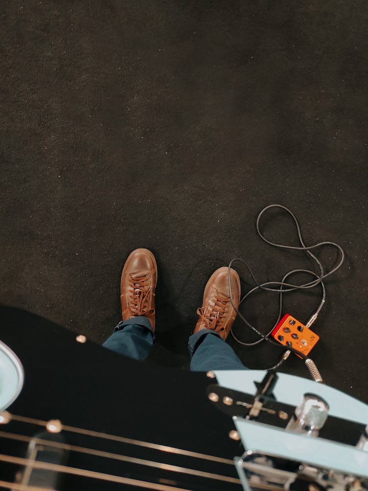 Point Of View Photography Of The Feet Of A Guitarist And Guitar 