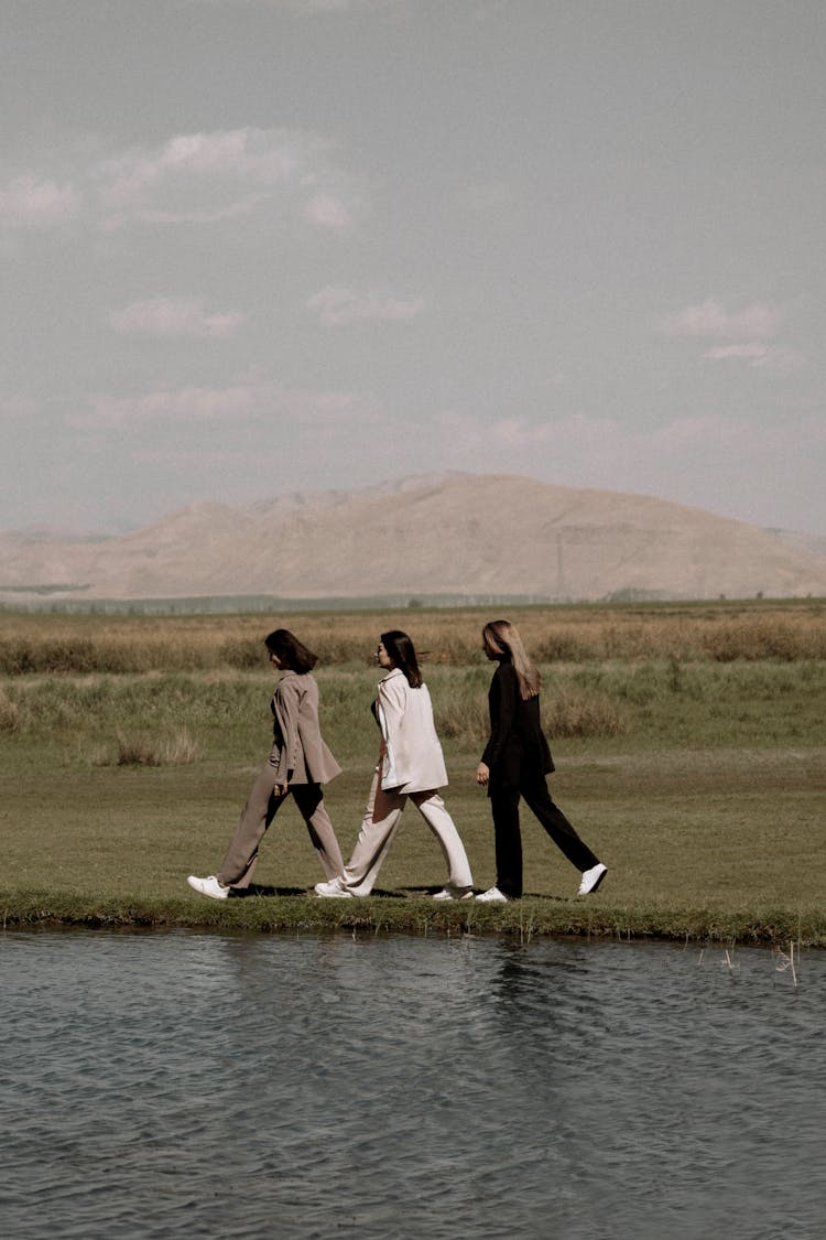 Three Women Walking Along The River