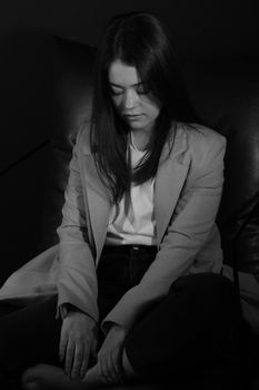 A serene black-and-white portrait of an Asian woman in a blazer, conveying calmness.