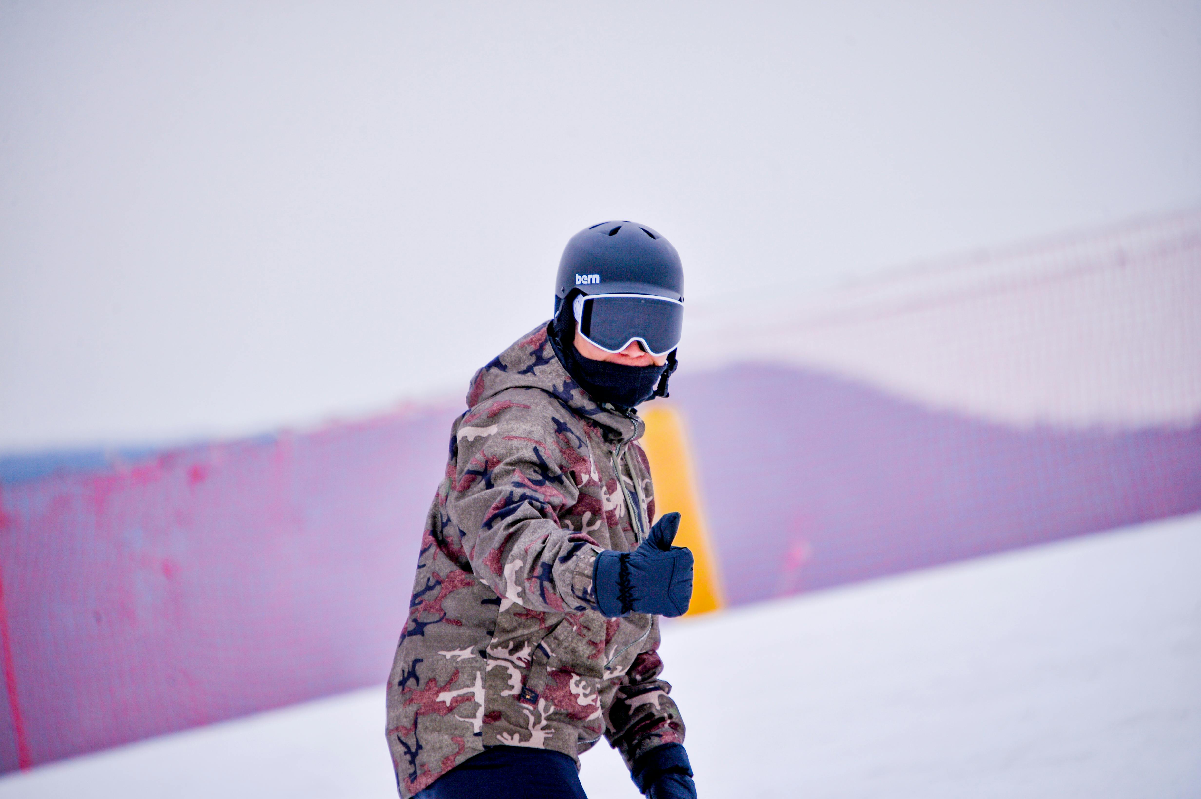 person in camouflage jacket and black helmet posing