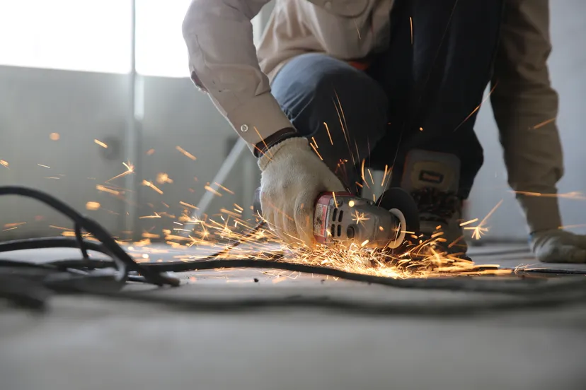 Trade worker cutting steel connection plates on site