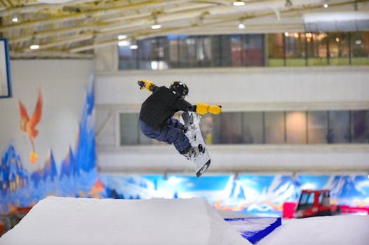 Snowboarder jumping mid-air indoors, showcasing extreme winter sports skills.
