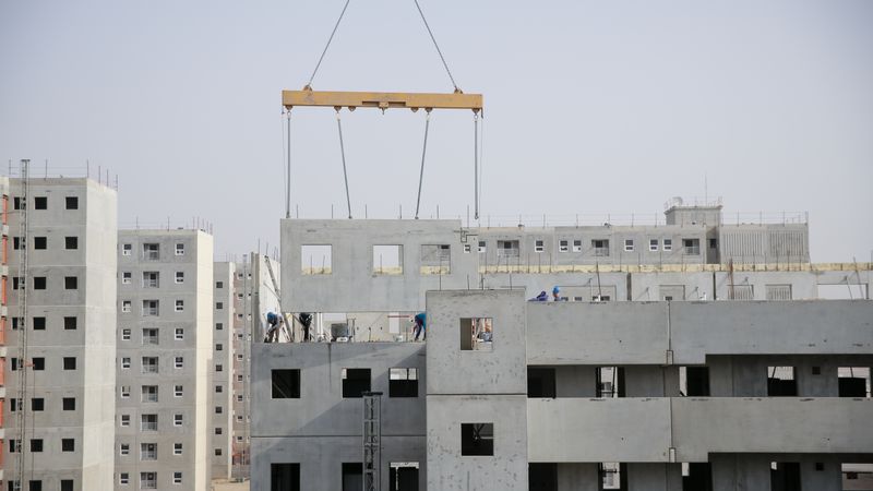 A precast concrete panel being lifted into place on a multi-storey building under construction