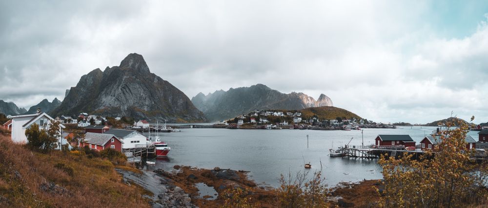 Panoramă asupra satului Reine, cu cabane roșii, munți și fiord