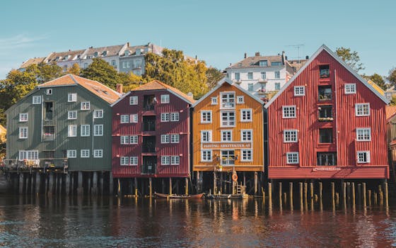 Traditional wooden houses along the river in Trondheim, Norway. A vibrant display of heritage architecture.