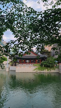 A traditional hanok house by a serene pond in Seoul, South Korea, captured during summer.