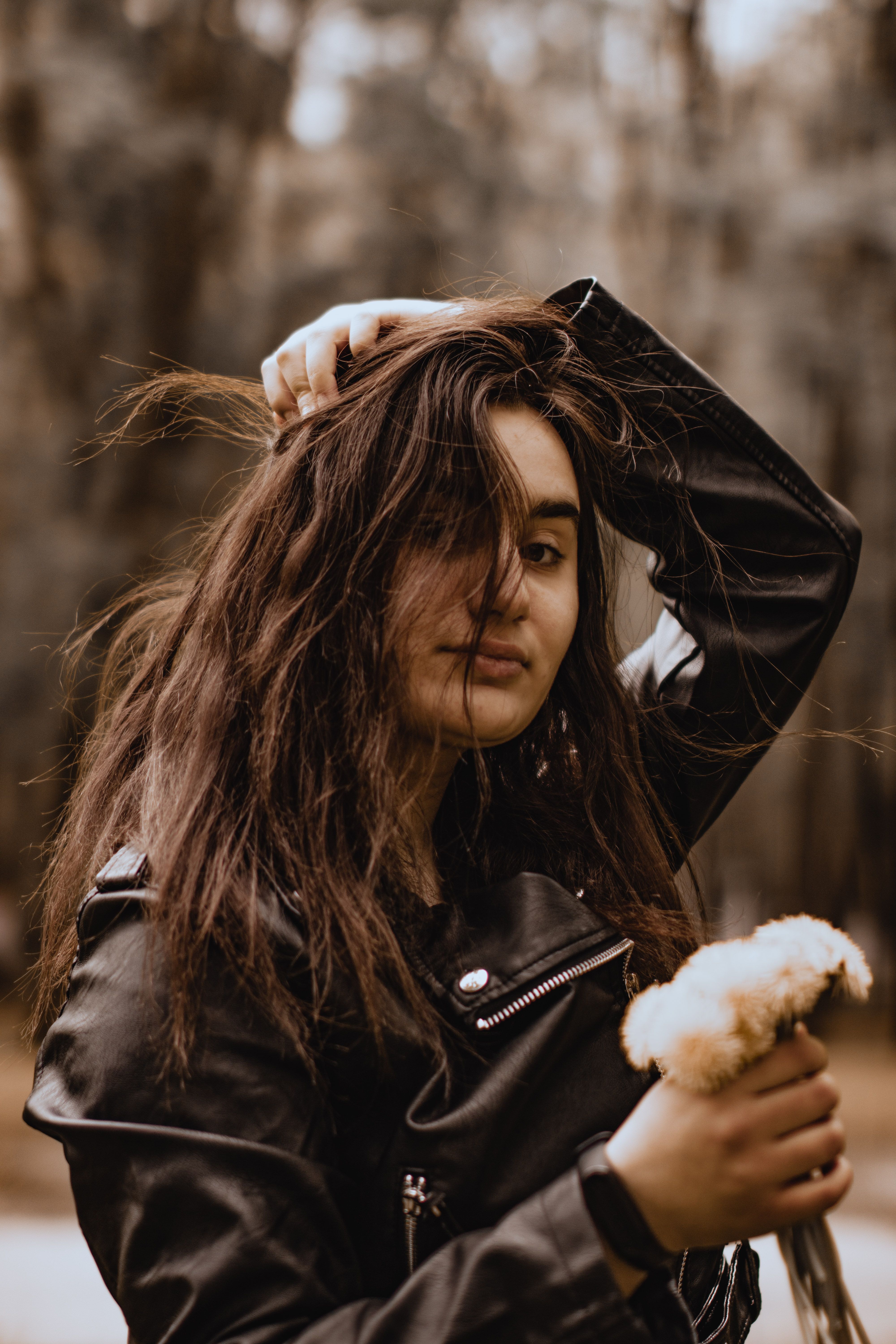 Selective Focus of a Woman in Black Leather Jacket Holding White ...