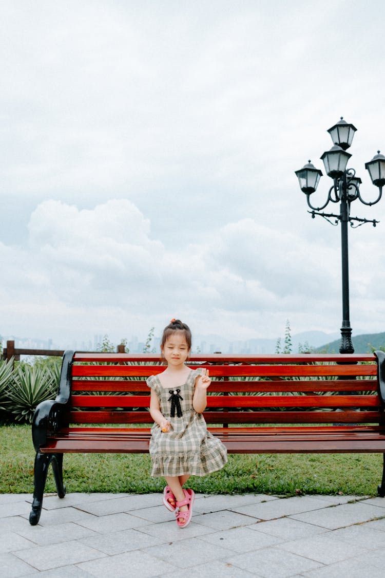 Little Girl Sitting On The Bench