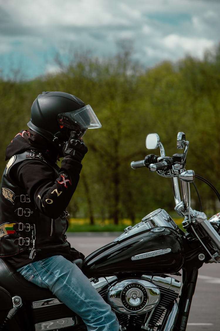 A Person Putting On A Black Helmet